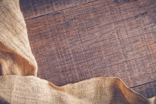 Wood table with old sackcloth burlap tablecloth texture with filter effect retro vintage style — Stock Photo, Image