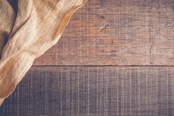 Wood table with old sackcloth burlap tablecloth texture with filter effect retro vintage style — Stock Photo, Image