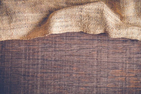 Wood table with old sackcloth burlap tablecloth texture with filter effect retro vintage style