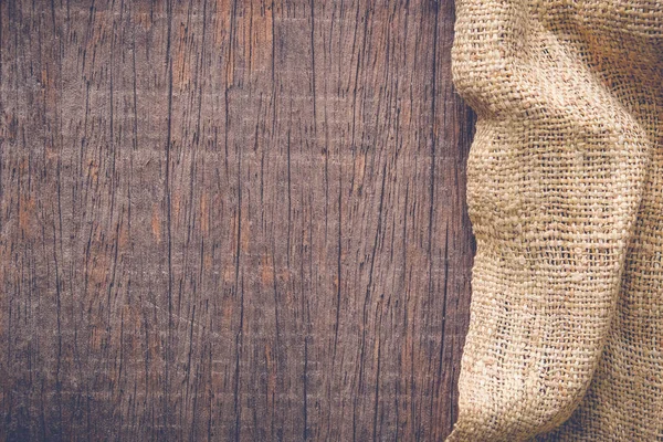 Wood table with old sackcloth burlap tablecloth texture with filter effect retro vintage style — Stock Photo, Image