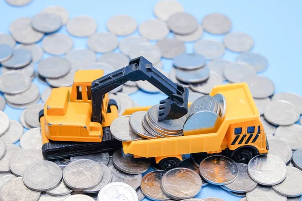 Bespaar geld voor investeringen concept vrachtwagen speelgoed en munten op blauwe achtergrond — Stockfoto