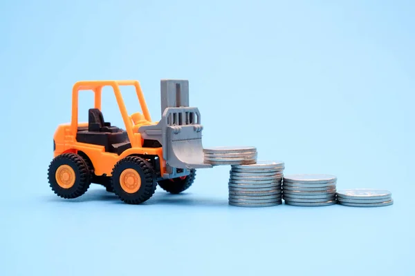 Save money for investment concept truck toy and Coins on blue background Royalty Free Stock Images