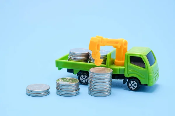 Bespaar geld voor investeringen concept vrachtwagen speelgoed en munten op blauwe achtergrond — Stockfoto