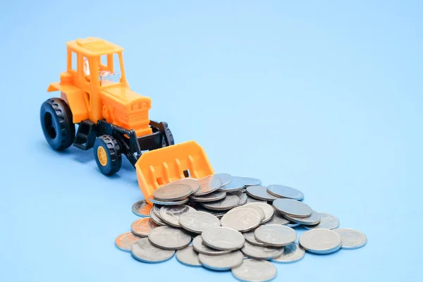 Bespaar geld voor investeringen concept vrachtwagen speelgoed en munten op blauwe achtergrond — Stockfoto