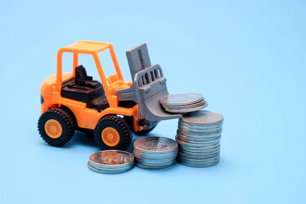 Save money for investment concept truck toy and Coins on blue background Stock Image