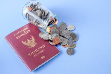 Tayland pasaportu kahverengi kapak ve para sikke üzerinde mavi kağıt arka plan tatil seyahat için