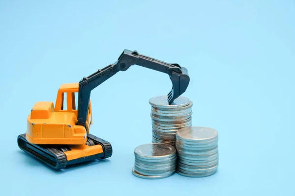 Save money for investment concept truck toy and Coins on blue background Royalty Free Stock Photos