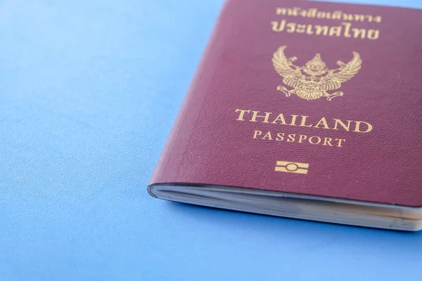 Tailandia pasaporte cubierta marrón sobre fondo de papel azul para viajar en vacaciones — Foto de Stock