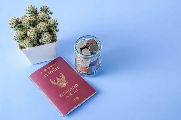 Tailandia pasaporte marrón cubierta y moneda de dinero sobre fondo de papel azul para viajar en vacaciones — Foto de Stock