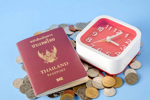 Tailandia pasaporte marrón cubierta y moneda de dinero sobre fondo de papel azul para viajar en vacaciones — Foto de Stock