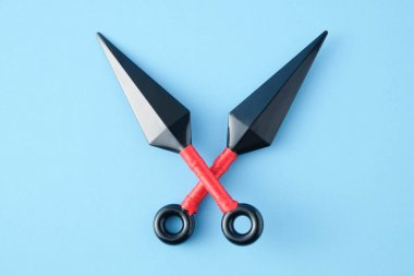 Ninja silah atmak için mavi kağıt arka plan üzerinde izole