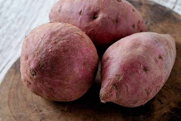 Filtre etkisi retro v ile ahşap arka plan üzerinde ham tatlı patates