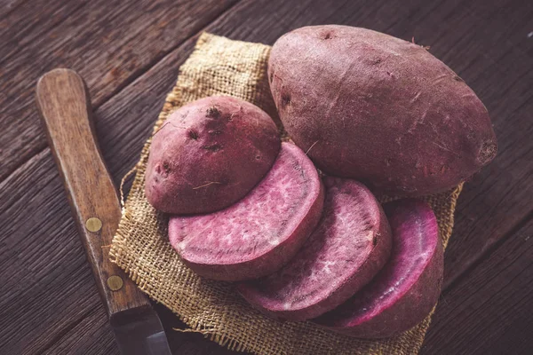 Filtre etkisi retro v ile ahşap arka plan üzerinde ham tatlı patates