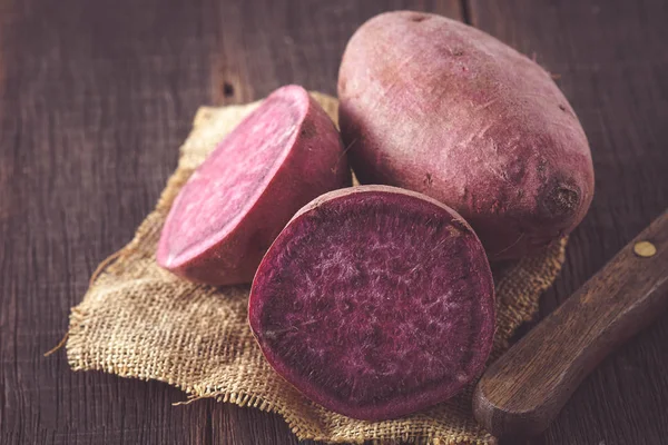 Raw sweet potatoes on wood background with filter effect retro v — Stock Photo, Image