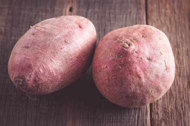 Filtre etkisi retro v ile ahşap arka plan üzerinde ham tatlı patates