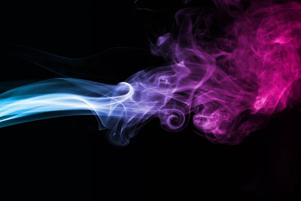 Humo azul y rosa abstracto sobre un fondo oscuro . — Foto de Stock