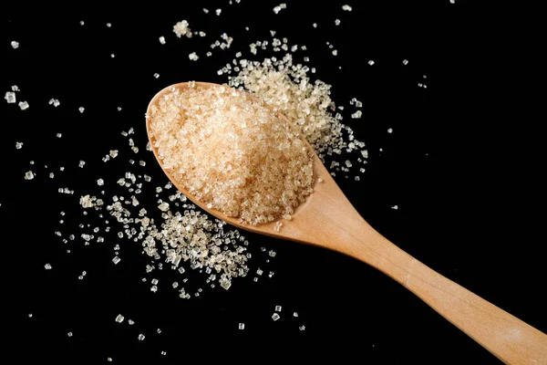 Brown sugar in wood spoon on black background.Components of The — Stock Photo, Image