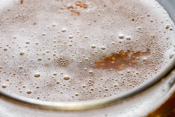 グラスに泡を入れたビールを背景に入れる — ストック写真