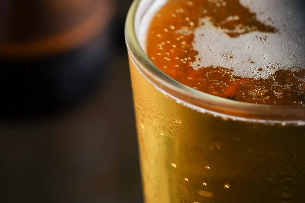 グラスに泡を入れたビールを背景に入れる — ストック写真