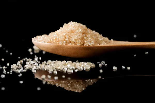 Brown sugar in wood spoon on black background.Components of The — Stock Photo, Image