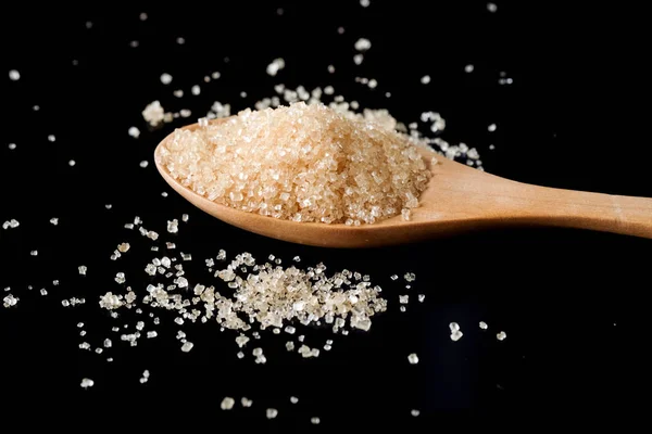 Brown sugar in wood spoon on black background.Components of The — Stock Photo, Image