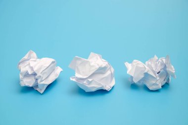 Mavi bir arka plan üzerinde buruşuk kağıt topları