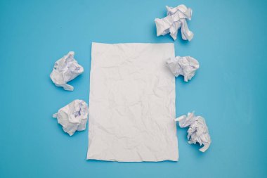 Mavi bir arka plan üzerinde buruşuk kağıt topları