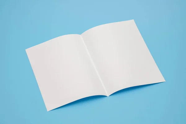 Modelo dobrar papel branco sobre fundo azul — Fotografia de Stock