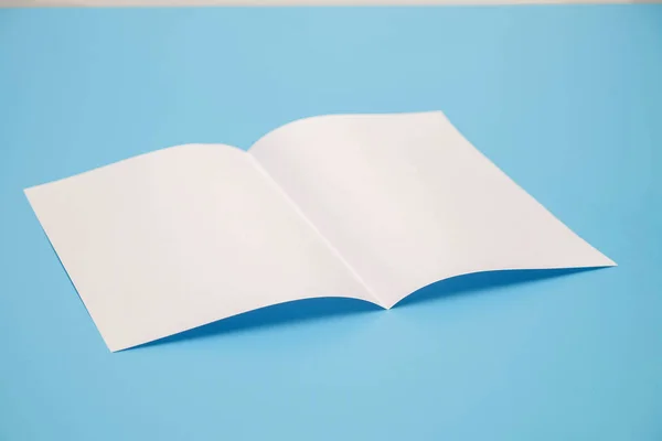 Modelo dobrar papel branco sobre fundo azul — Fotografia de Stock
