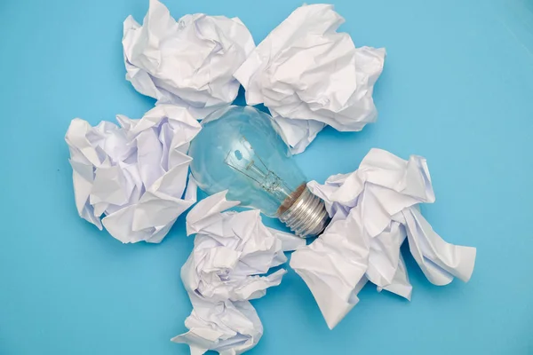 Great concept with crumpled office paper and light bulb on a blue background — Stock Photo, Image