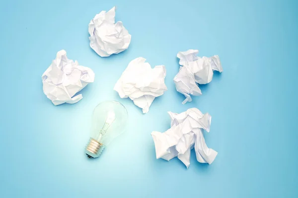 Great concept with crumpled office paper and light bulb on a blue background Stock Picture