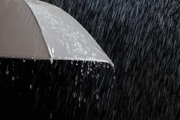 Wet protection umbrella in stormy weather with natural thunderstorm, on black background, — Stock Photo, Image