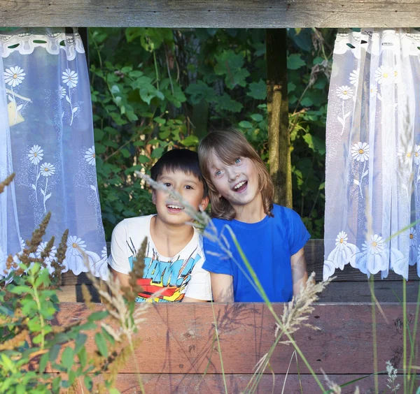 Dos chicos sentados en una cabaña en el jardín divirtiéndose . —  Fotos de Stock