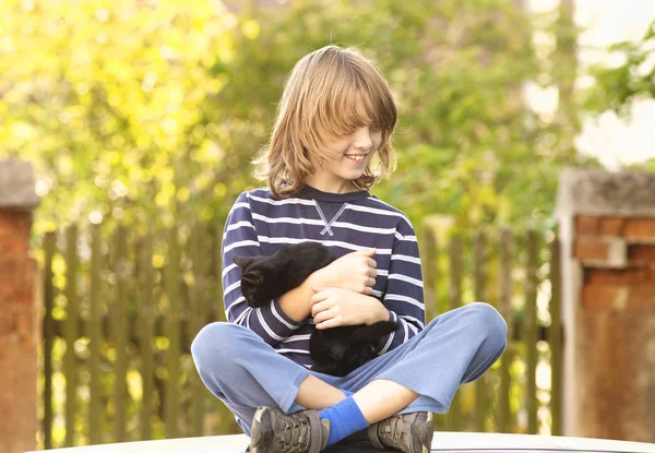 Pojken sitter håller en sällskapsdjur kattunge — Stockfoto