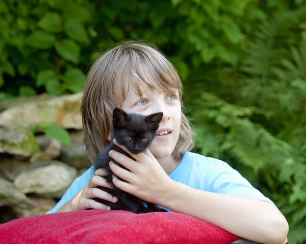 Retrato de un niño sosteniendo un gatito al aire libre — Foto de Stock