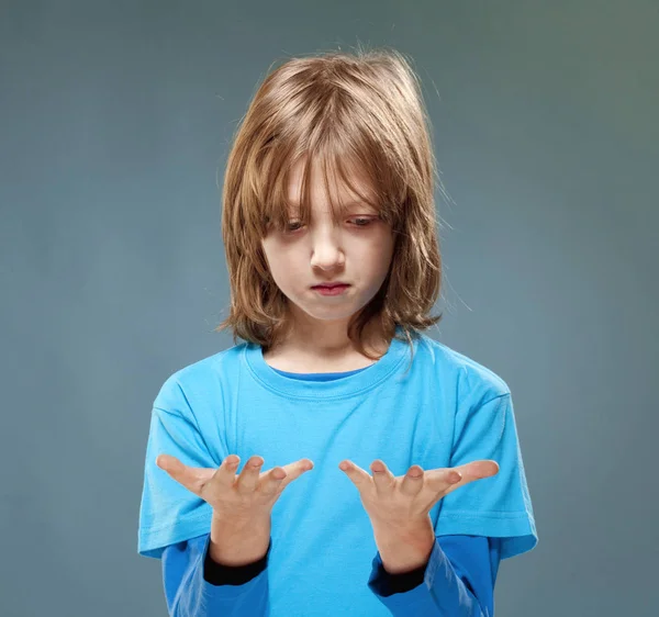 Ragazzo in blu Top Guardando le sue mani — Foto Stock