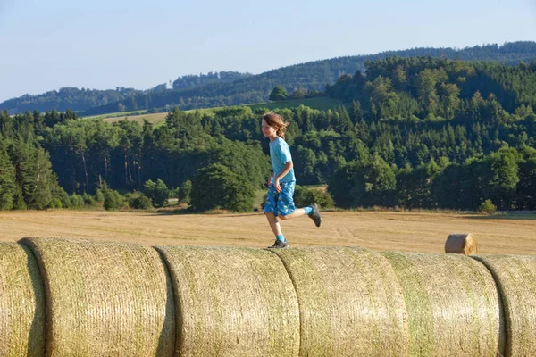 Niño corriendo en balas de heno —  Fotos de Stock