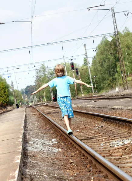 Pojken går på järnvägsspår — Stockfoto
