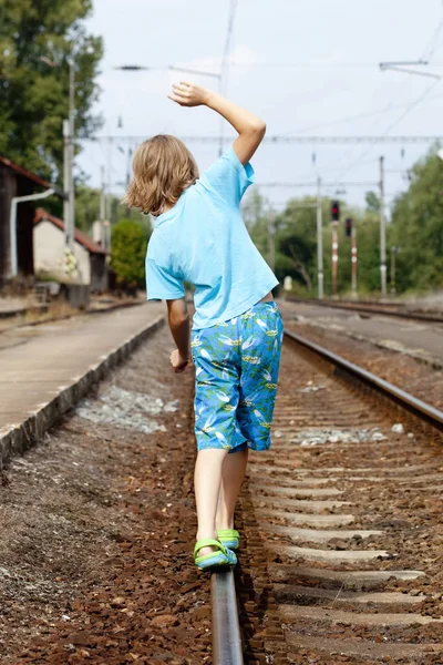 Rayların üzerinde yürürken çocuk