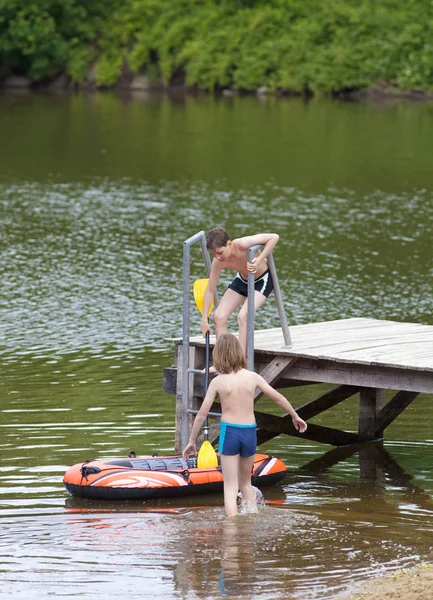 Twee jongens met plezier met opblaasbare rubberboot dobbert — Stockfoto