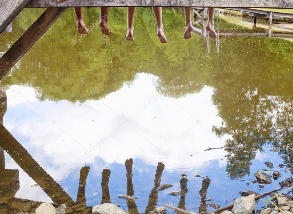  Legs Dangling Down from Wooden Pier over Water