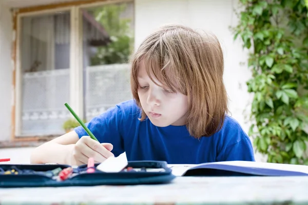 Мальчик с блондинкой рисует картину — стоковое фото