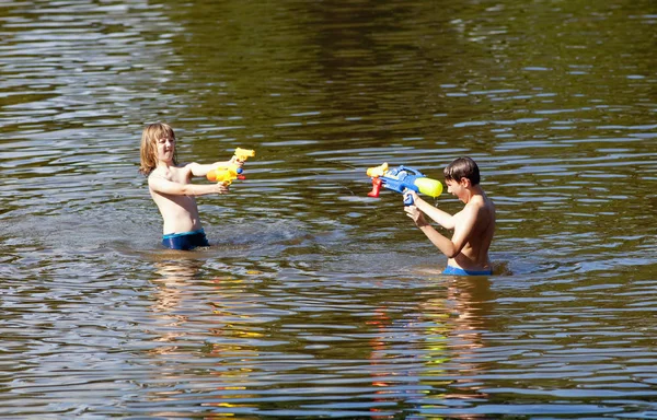 Twee jongens vechten met Squirt kanonnen. — Stockfoto