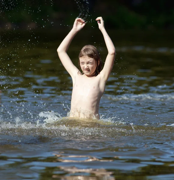 Jongen met plezier Jumping up en opspattend Water — Stockfoto