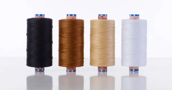 Cuatro carretes de hilo de coser de diferentes colores — Foto de Stock