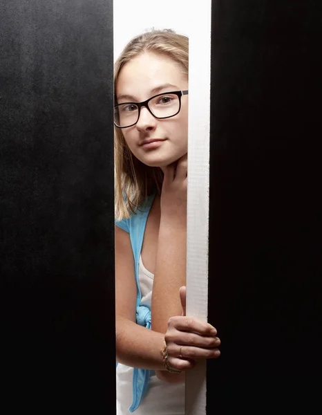 Curiosa chica mirando desde detrás de puertas — Foto de Stock