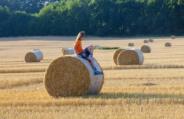 Chlapce, který seděl na balík sena v létě — Stock fotografie