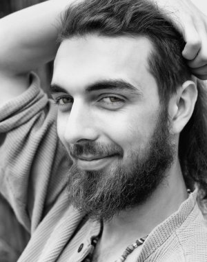 Uzun saç ve sakal ile bir genç çocuk portresi.