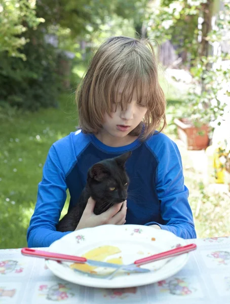 Jongen Holdning een kat aan de tafel. — Stockfoto