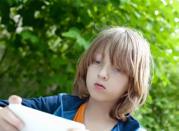 Niño leyendo el mensaje de texto en el teléfono móvil — Foto de Stock